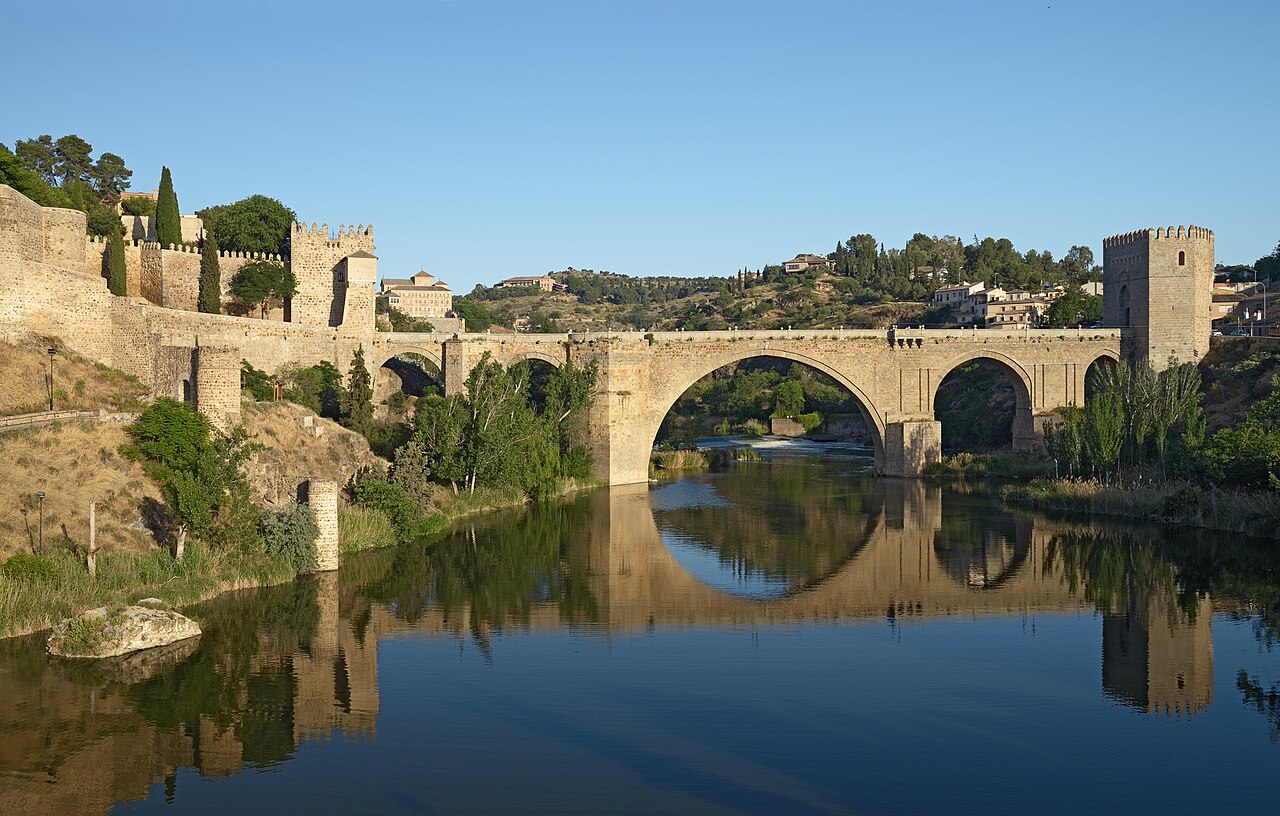 Puente medieval de San Martín reflejado sobre el río Tajo en Toledo