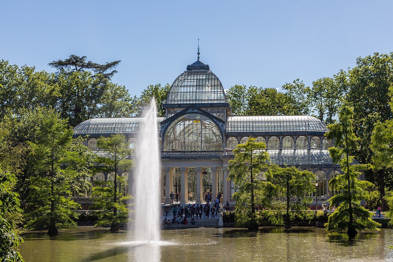 Palacio de Cristal en el Parque del Retiro de Madrid reflejado en el estanque rodeado de cipreses de los pantanos