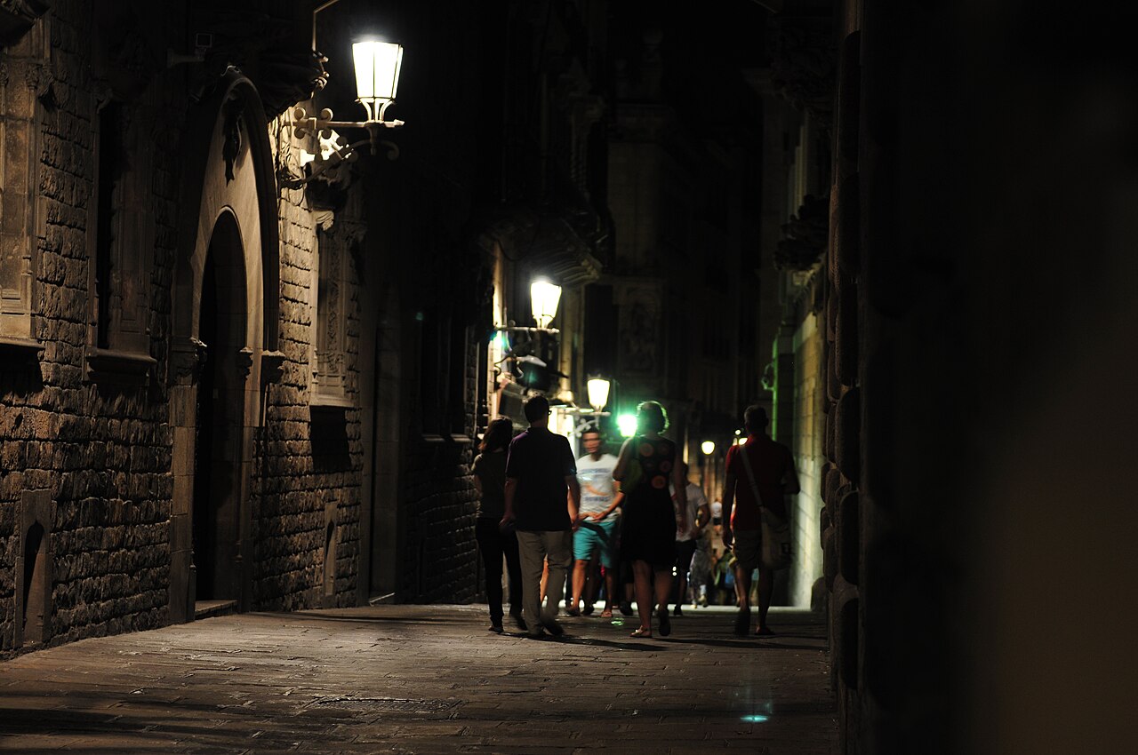 Callejón histórico iluminado con faroles de noche en el Barri Gòtic de Barcelona