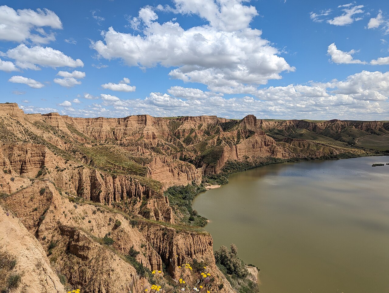 Acantilados de arcilla rojiza de las Barrancas de Burujón sobre el embalse de Castrejón en una escapada de día desde Madrid