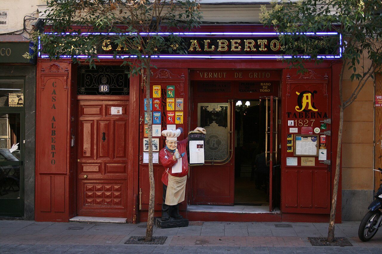 Fachada histórica de madera roja de la taberna centenaria Casa Alberto en la calle de las Huertas de Madrid