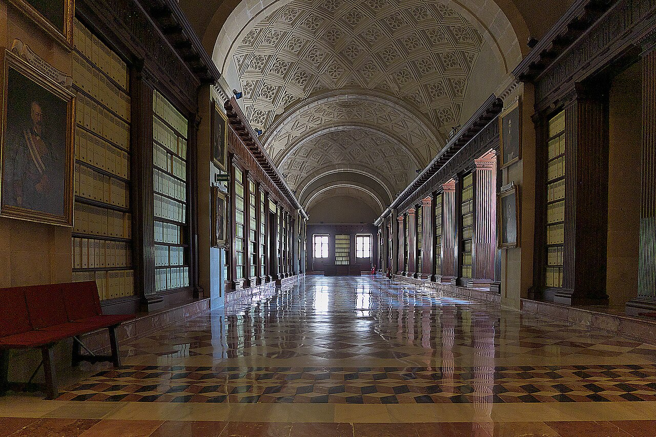 Galería renacentista en penumbra del Archivo General de Indias junto a la Plaza del Triunfo y el acceso a Santa Cruz