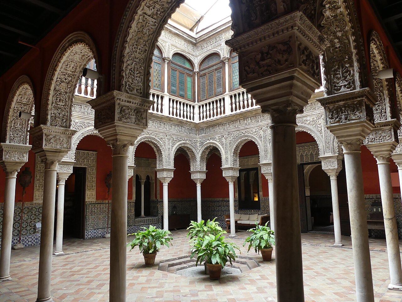 Columnas de mármol y arcos con yeserías en un patio mudéjar sevillano del siglo XVI