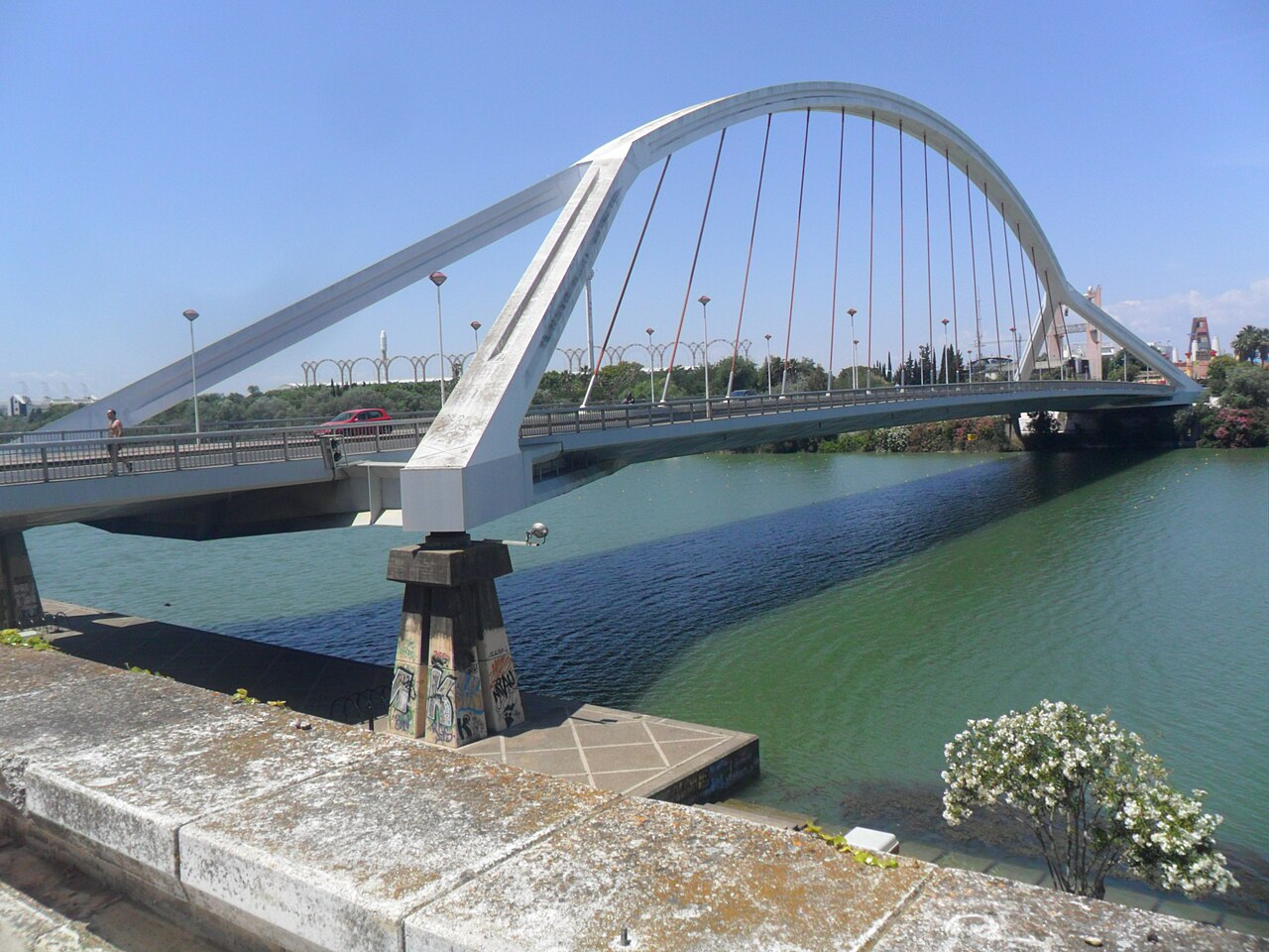 Arco blanco del Puente de la Barqueta sobre la dársena del río Guadalquivir en Sevilla