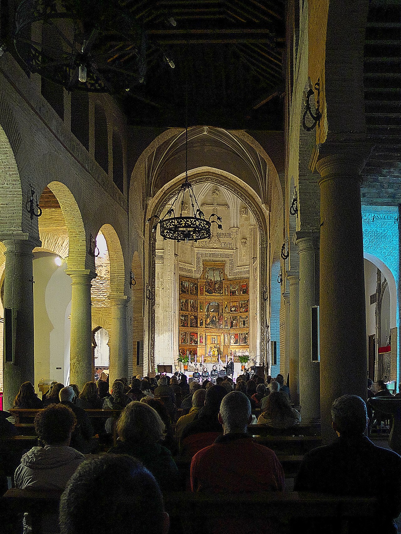 Interior de arcos mudéjares y retablo mayor iluminado en la Iglesia de San Andrés de Toledo