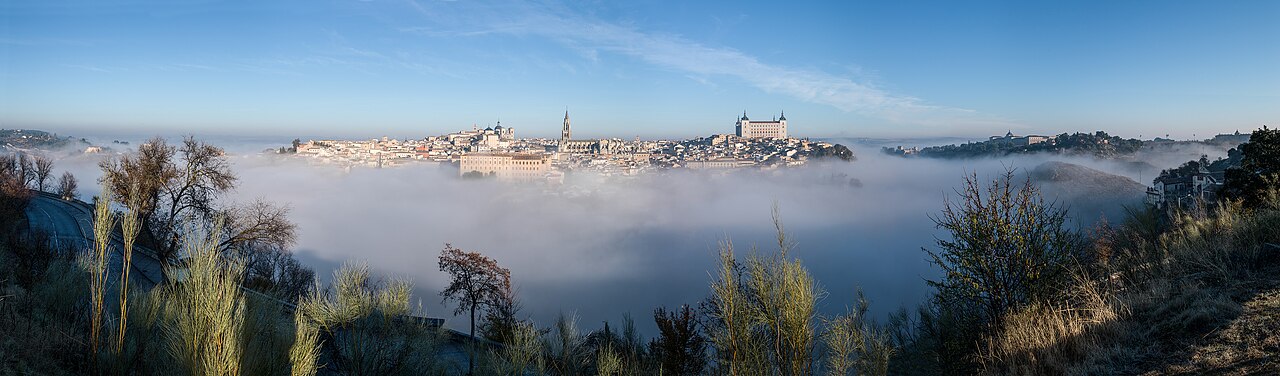 Panorámica del casco histórico de Toledo y el Alcázar emergiendo sobre un mar de niebla otoñal en el cañón del Tajo