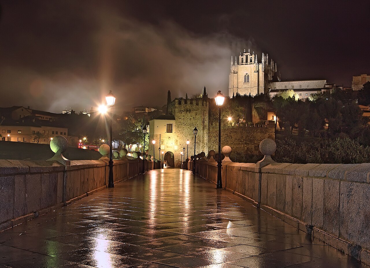 El Puente de San Martín y el Monasterio de San Juan de los Reyes en Toledo iluminados de noche entre la niebla de otoño